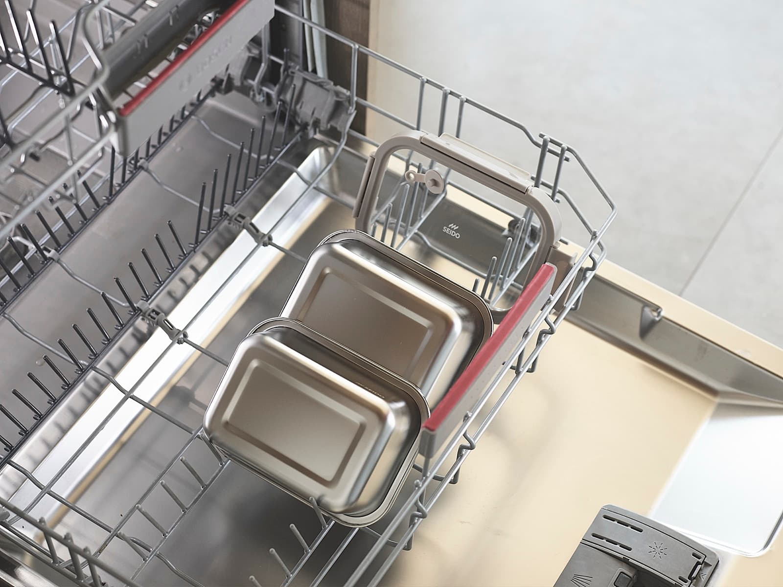 Stainless steel lunch boxes in a dishwasher rack