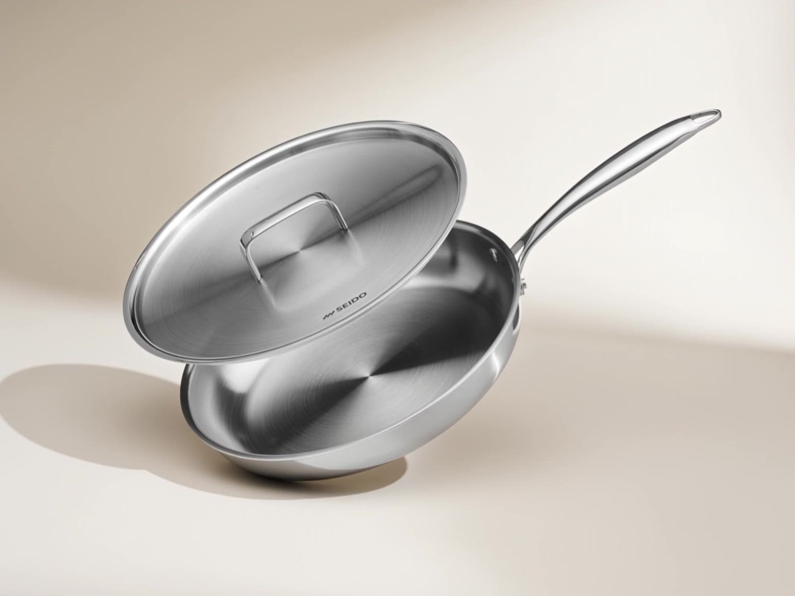 SEIDO stainless steel skillet with lid on a cream background