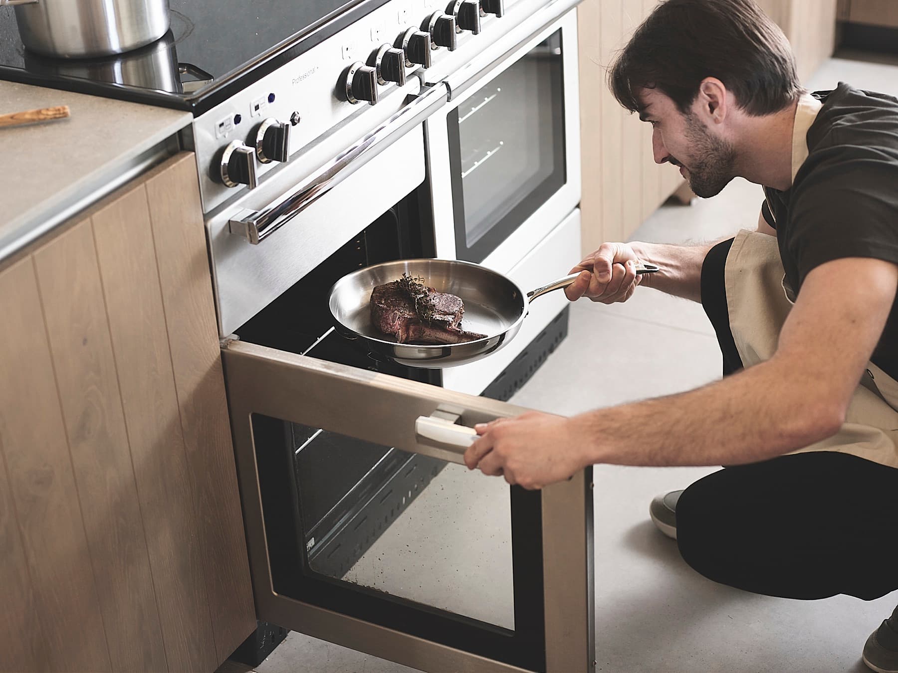 Uncoated stainless steel skillet going into an oven
