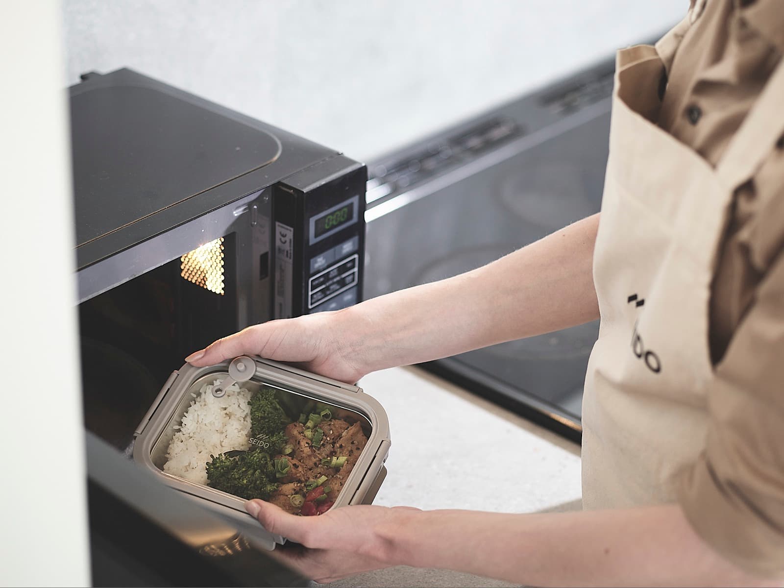 SEIDO stainless steel lunch box being placed in a microwave