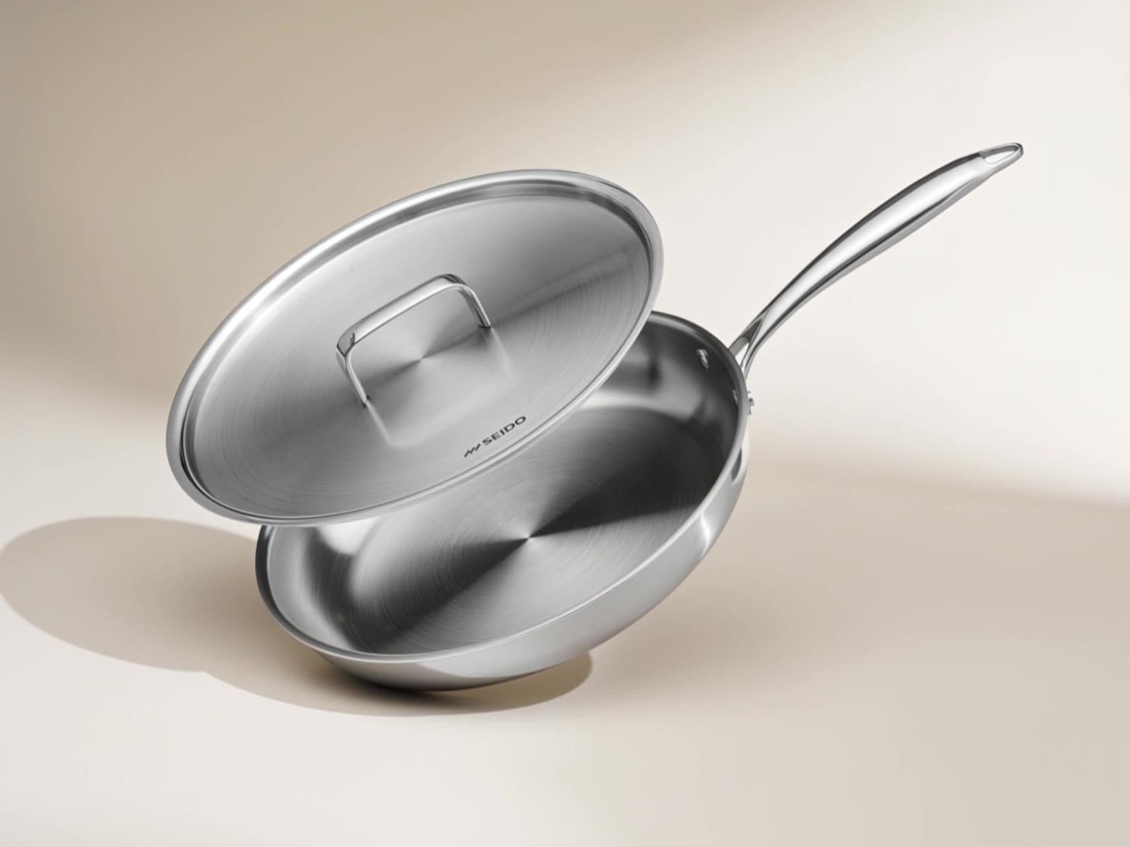 SEIDO stainless steel skillet with lid on a cream background